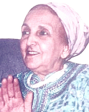Mama Ghita smiling, wearing a headscarf and embroidered kaftan